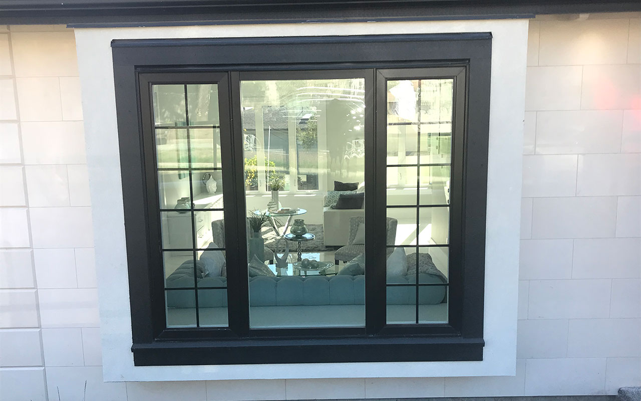 Large black-framed picture window with grid bars on a white wall