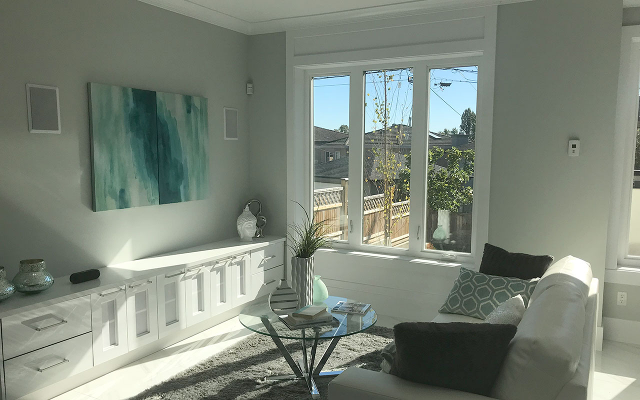 Bright living room with a white built-in cabinet, sofa and large windows